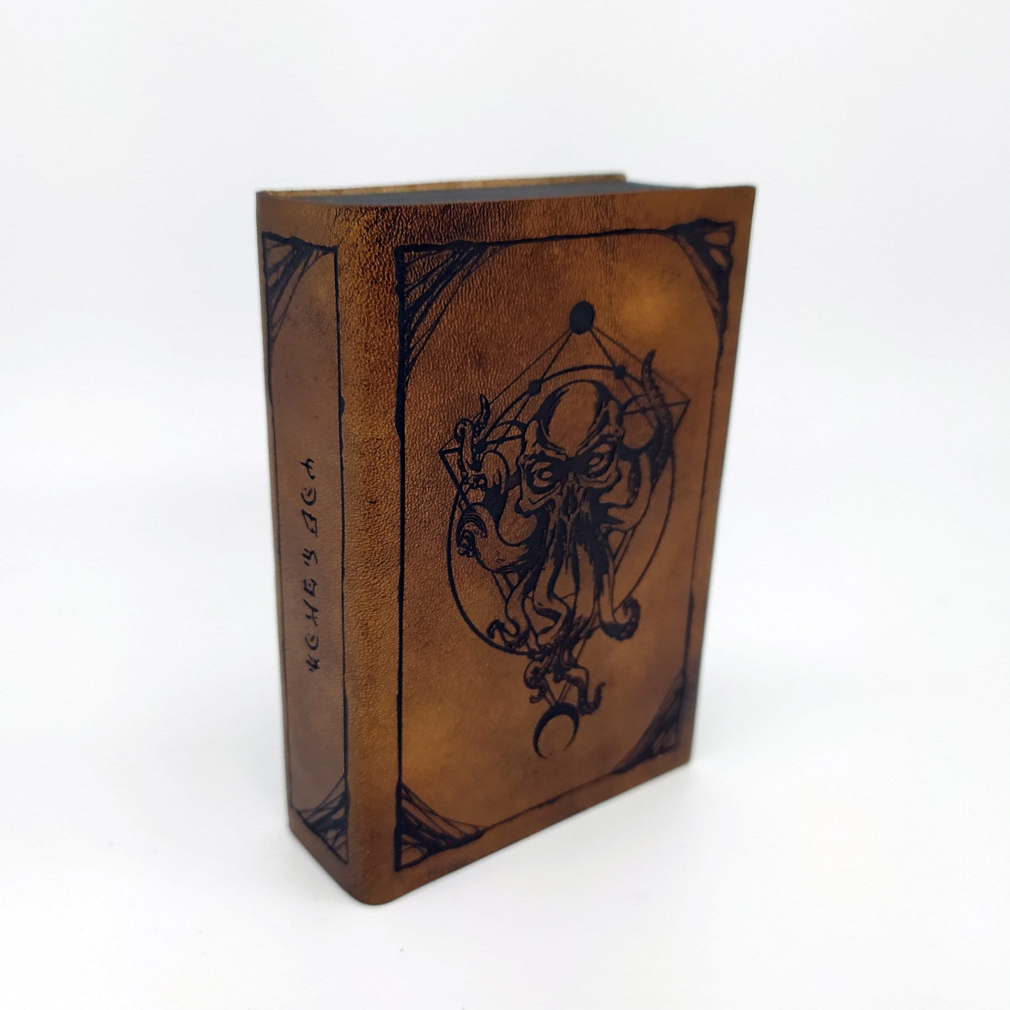 Porta dadi artigianale in legno e pelle a forma di tomo antico con incisione di Cthulhu, accessorio per giochi di ruolo.