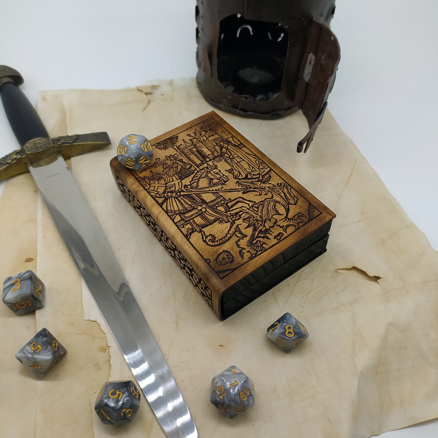 Porta dadi artigianale in legno e pelle a forma di antico libro con incisione di San Giorgio, accessorio per giochi di ruolo.