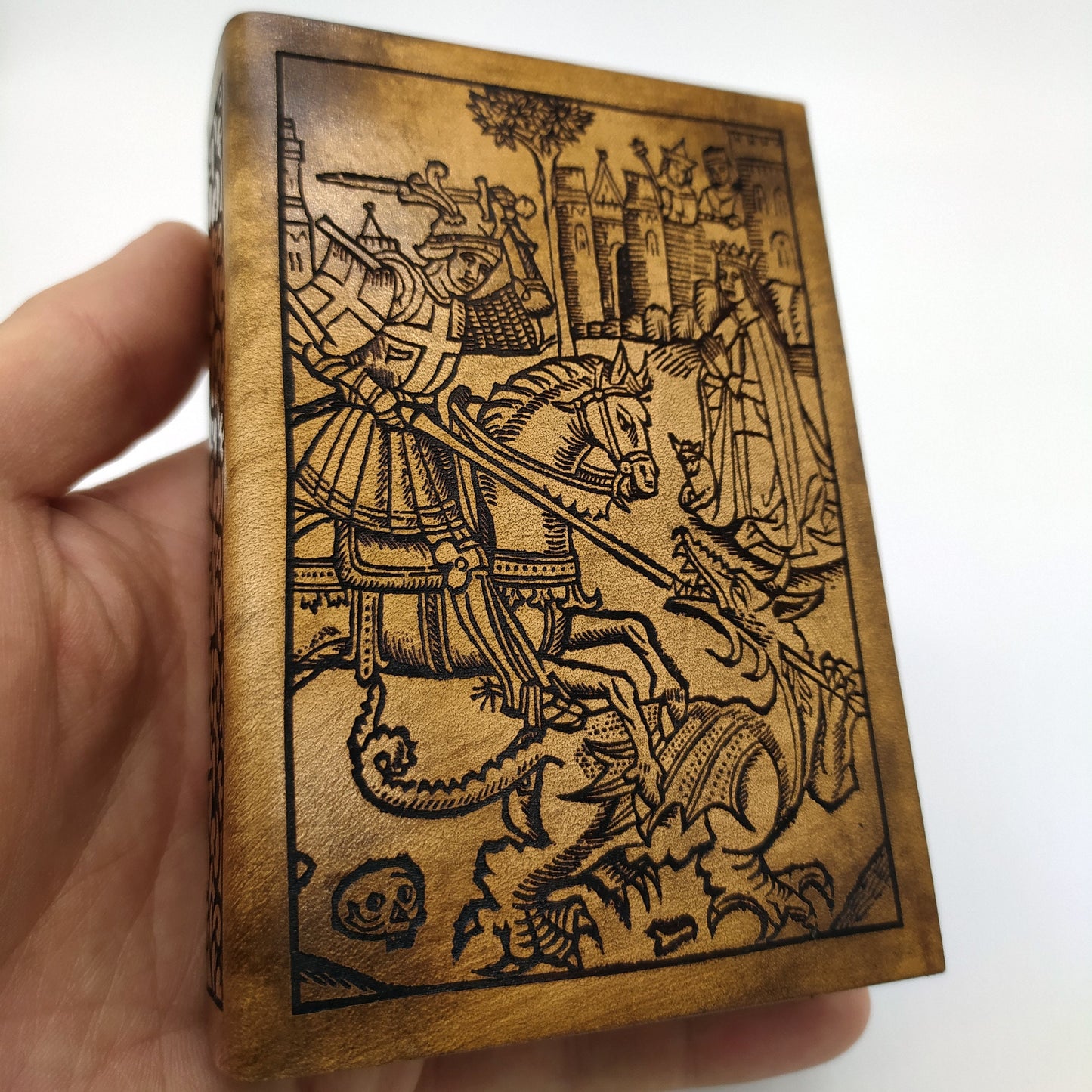 Porta dadi artigianale in legno e pelle a forma di antico libro con incisione di San Giorgio, accessorio per giochi di ruolo.